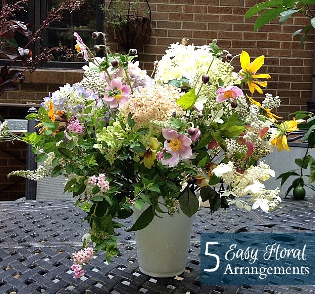 Country cottage summer flower arrangemenst with multiple flowers including anemone, hydrangea, rudbeckia, and yarrow.