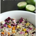 Quinoa salad with veggie and black beans in a white bowl with text and fresh limes