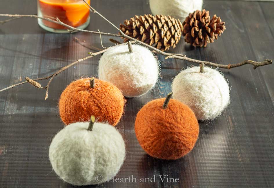 Hand crafted yarn pumpkins, a tree branch and some pinecones.