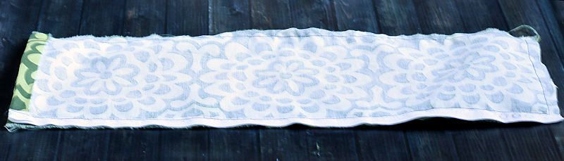 Sewn long edges of rectangular pad.