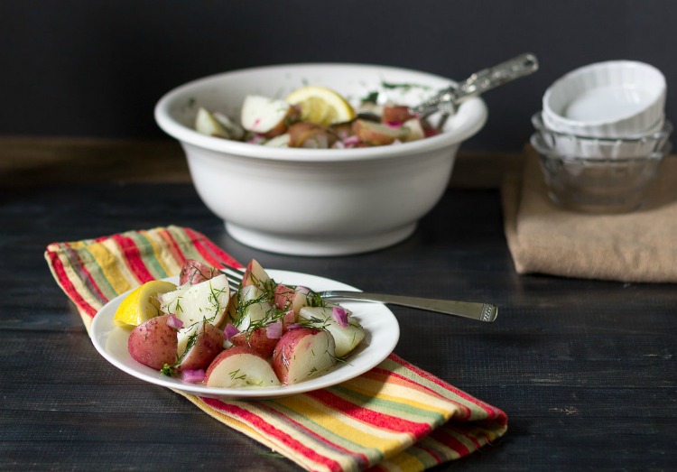 Plate of dill and lemon red potato salad and larger bowl in the background