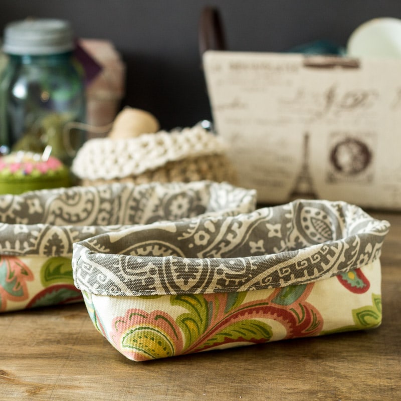 Two fabric bins to hold utensils in two different fabrics.