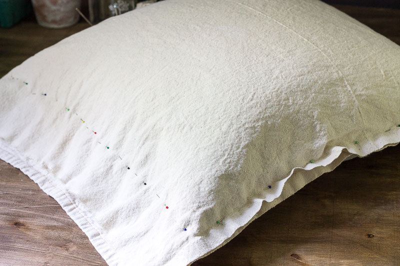 Pinning the drop cloth fabric around an old pillow.