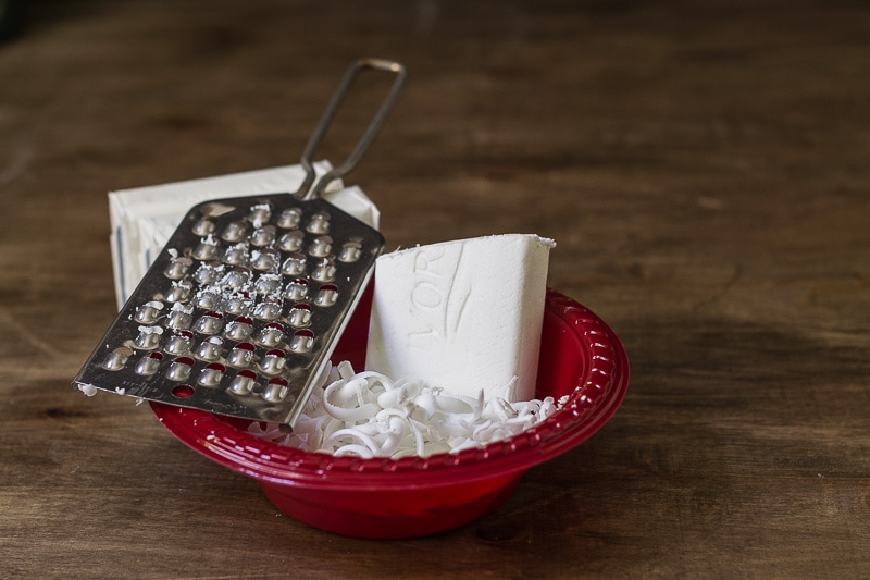 Cheese grater in a bowl with bars of Ivory soap. Some soap is grated.