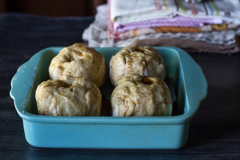 Apple dumplings prepared in a baking dish ready for the oven.