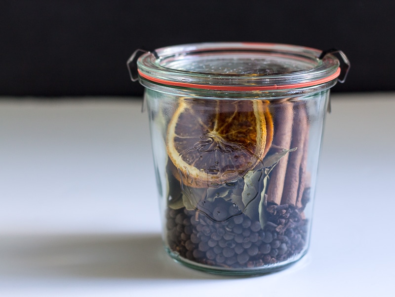 Stovetop Potpourri in a Weck jar with bay leaves, cinnamon sticks, allspice, and dried orange slices.