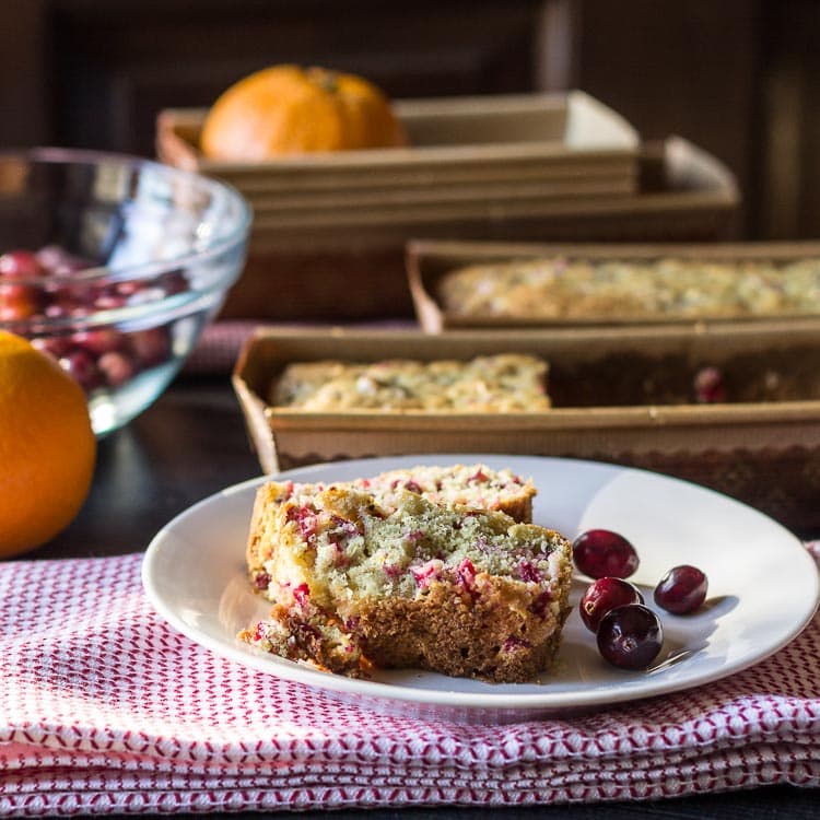 Cranberry orange bread slices with cranberries and loaves.