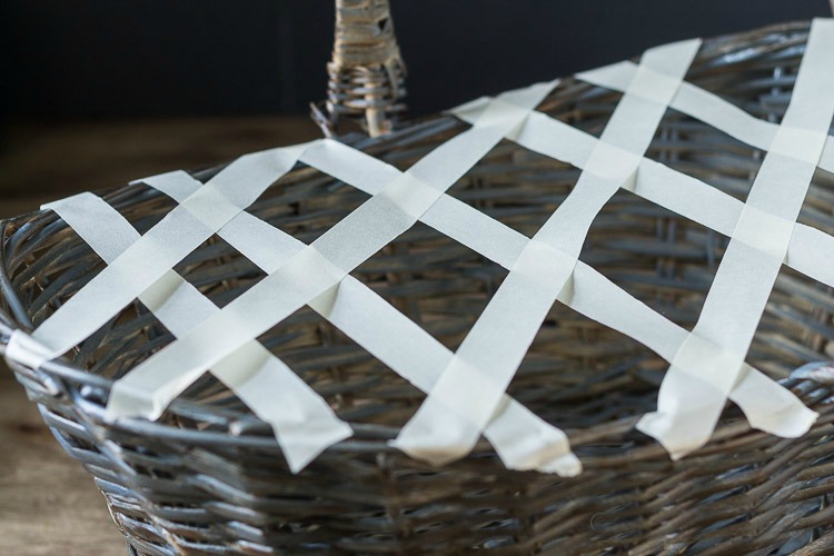 Using tape to create lattice on basket to hold flowers