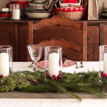 Easy Centerpiece with Fresh Greens Cranberries and Candles on a Wood Plank