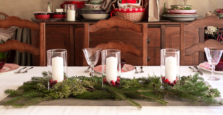 Easy Centerpiece with Fresh Greens Cranberries and Candles on a Wood Plank