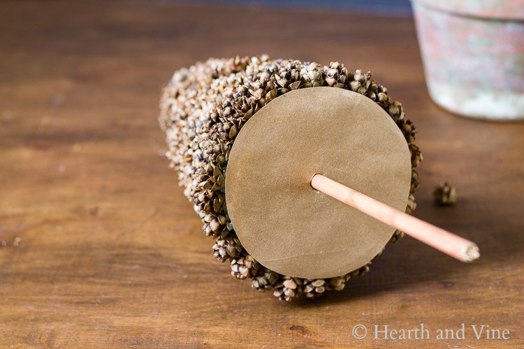 Kraft paper base with dowel rod for trunk inserted into cone.