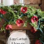 Egg carton flower garland mini lights with candles on mantel.