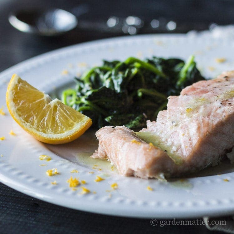 Meyer lemon butter sauce on baked salmon and wilted fresh spinach.