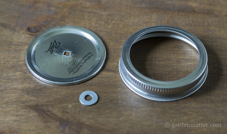 Mason jar lid with a hole and a washer to use as a dispenser for natural twine.