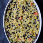 Oval casserole dish with Mexican black beans and rice.