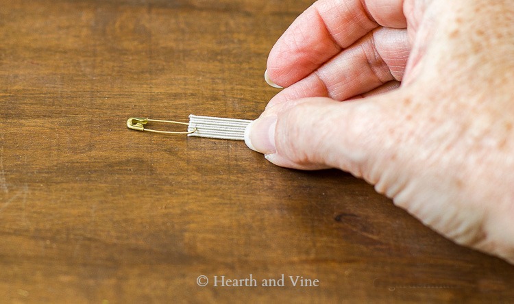 Safety pin on end of elastic thread