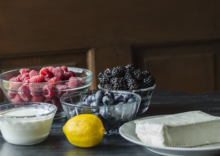 Some ingredients for low sugar no bake cheesecake recipe. Cream cheese, lemon, raspberries, blackberries and cream.
