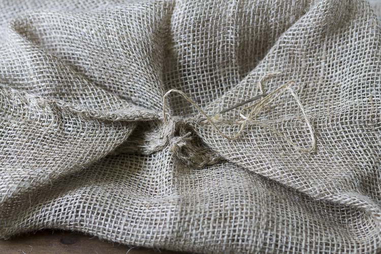 Corners of burlap sack sewn together to create bottom.