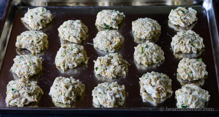 Crab cakes prepped on baking sheet.