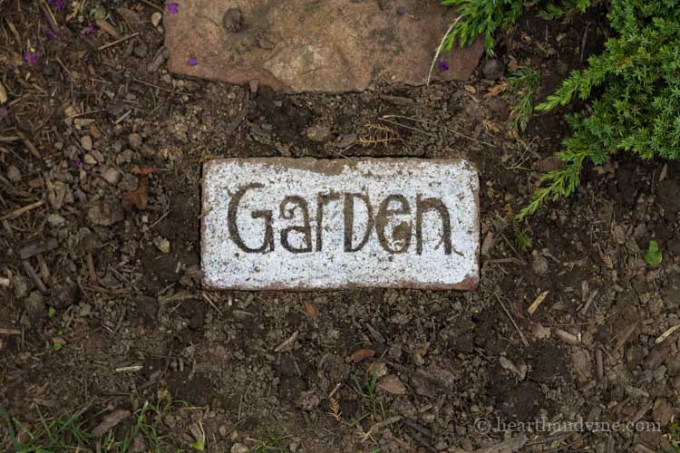 Brick garden path with the word Garden on a brick.