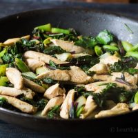 Pan with stir fried chicken, greens and snap peas.