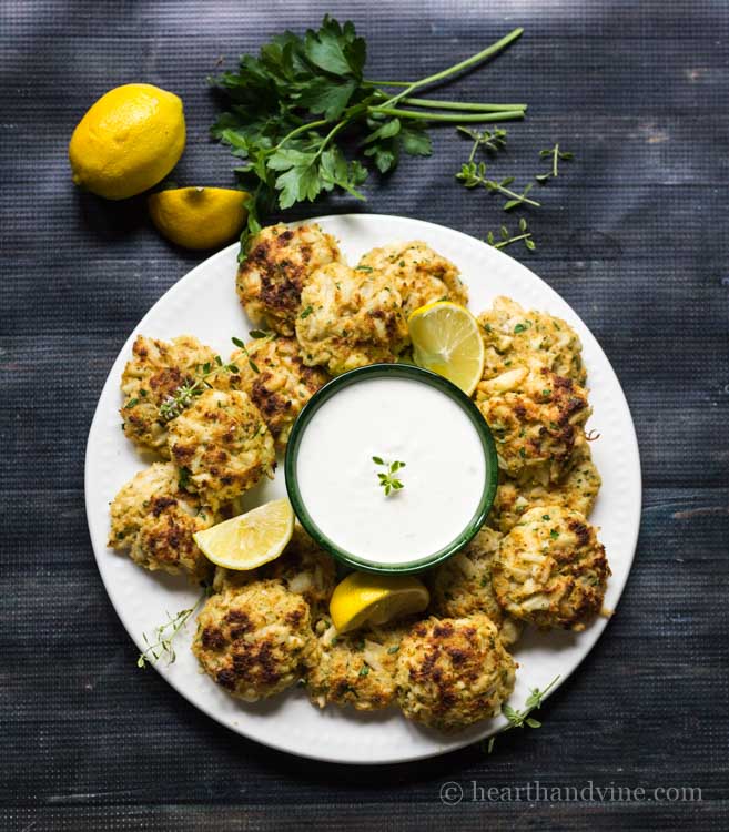 Plated mini crab cakes with creamy lemon thyme dip.