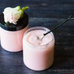 Open jar of blush pink sugar body scrub.