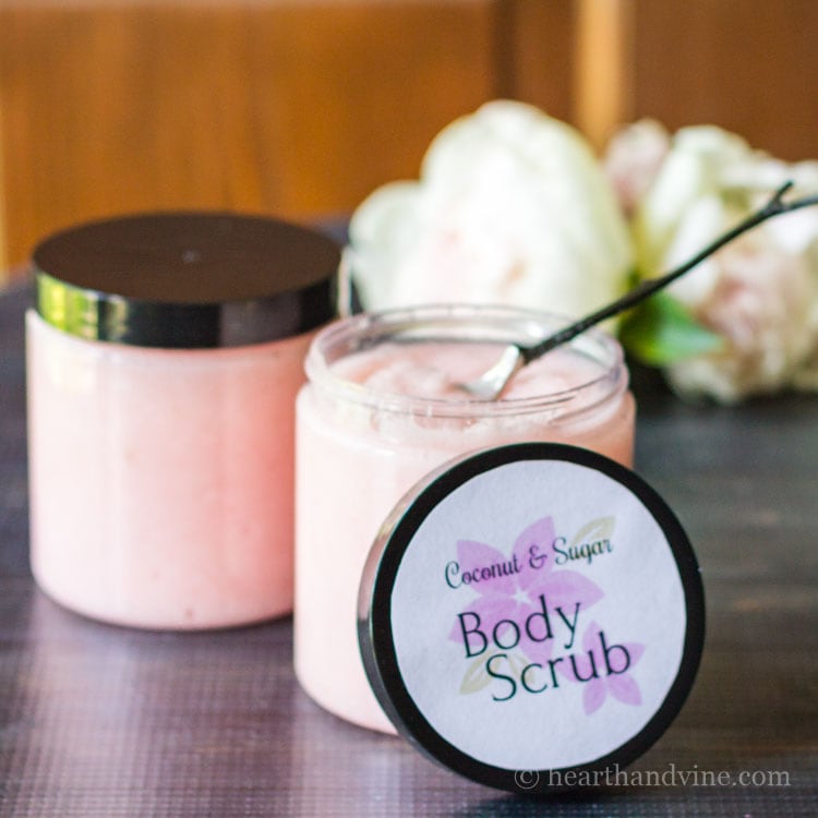 Blush pink homemade sugar body scrub jars with round label on lid.