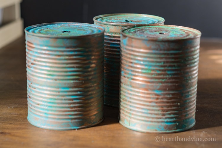 Three tin cans with verdigris craft paint technique
