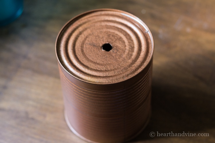 Tin can with drilled hole and spray painted copper.