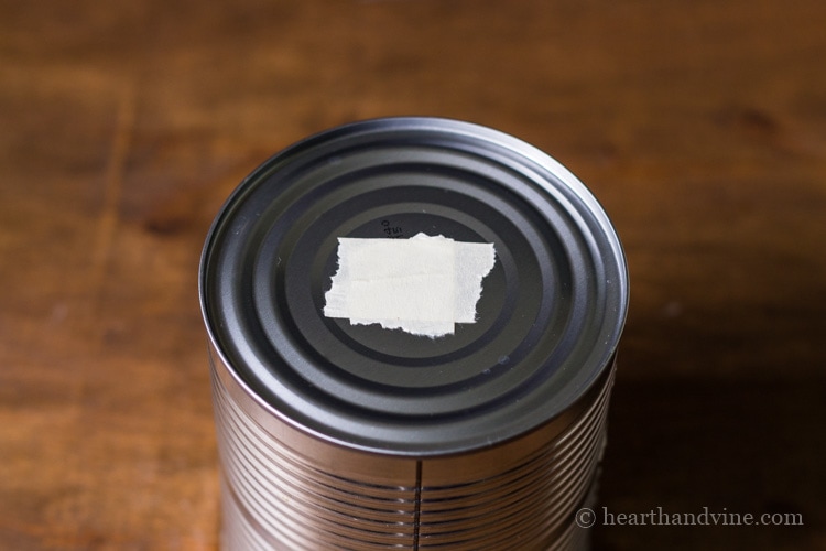 Empty tin can with masking tape on center