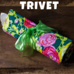 Floral fabric trivet rolled up with wooden spoons and tied with a ribbon.