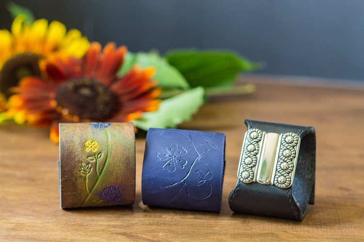 Three different leather bracelets made from belts and a piece of leather.