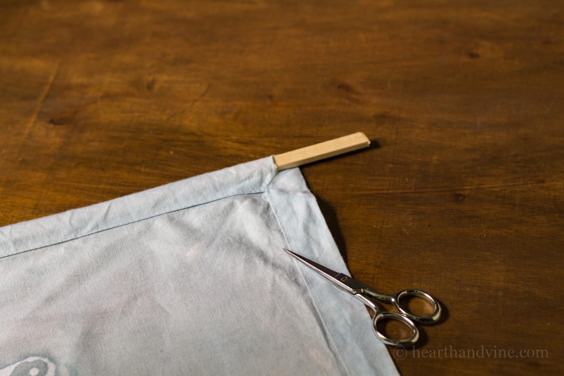 Adding a hanging dowel rod in hem of napkin for wall hanging.