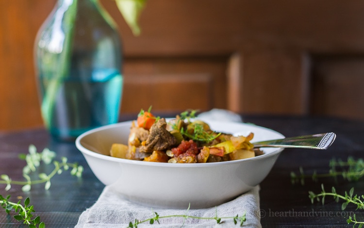 Side view of a serving bowl of vegetable beef stew.