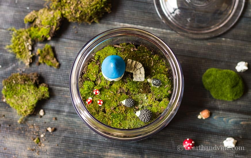 Fairy garden accessories in glass jar.