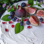 Top of decorated chocolate naked cake with figs, pomegranate seed and mint flowers