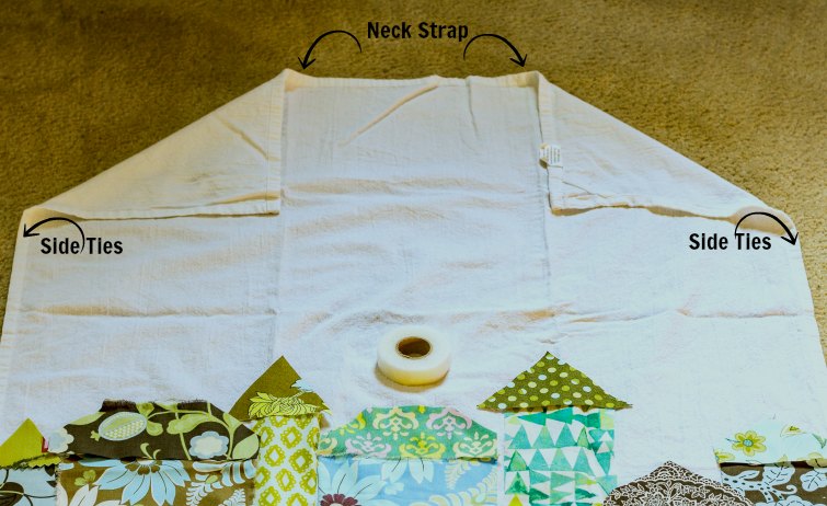 Folded corners of tea towel and marking where to sew side ties.