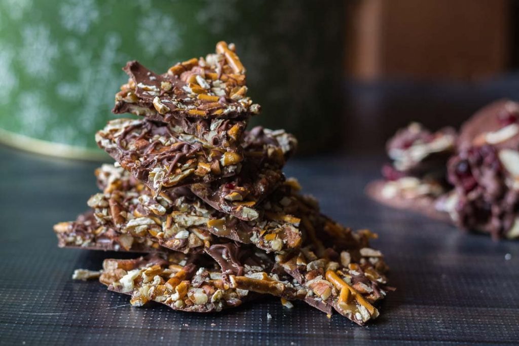 Chocolate bark candy with pretzels and pecans stacked.