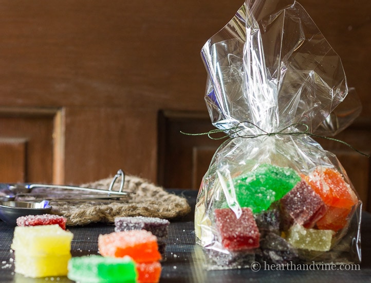 Jelly candy in assorted color and flavors. A few on the table and some in a plastic gift bag.