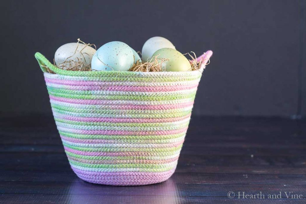 Dyed rope basket with colored eggs.