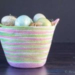 Dyed rope basket with colored eggs.
