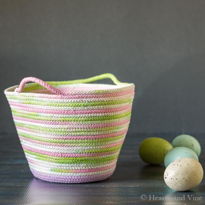 Dyed rope basket for Easter next to eggs.