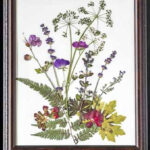 Pressed flowers arranged as a bouquet on paper and then framed as artwork.