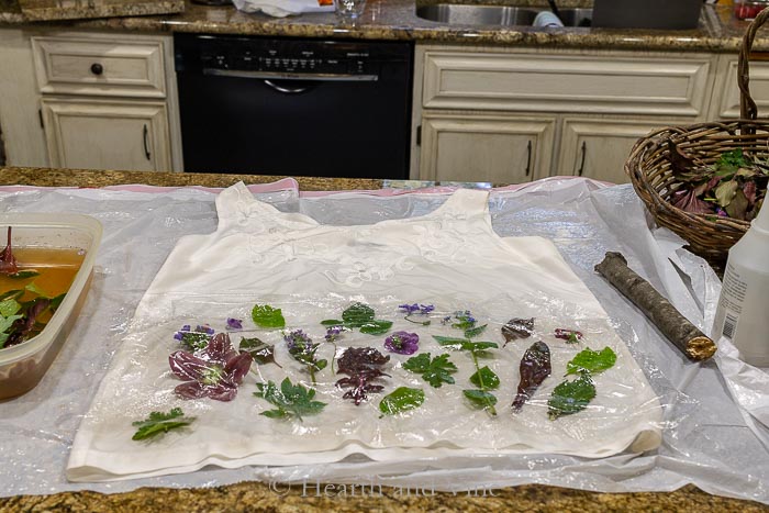 Silk blouse with plant material covered in plastic wrap.