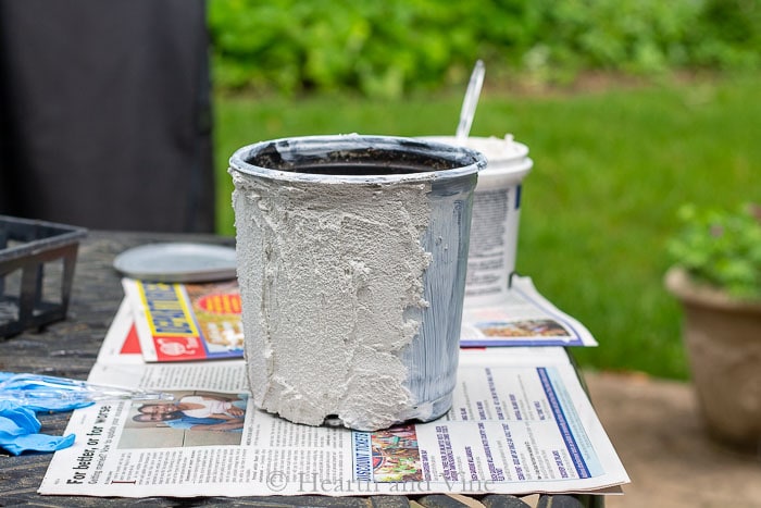 Spreading grout on plastic pot.