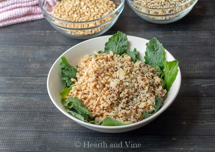 Cooked farro, quinoa and raw baby kale.
