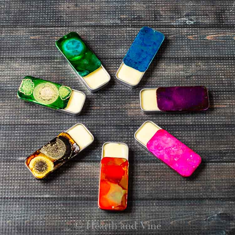 Circle of solid perfume tins in decorated in a variety of colors with alcohol inks.