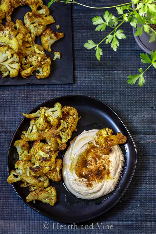 Spicy roasted cauliflower pieces with hummus