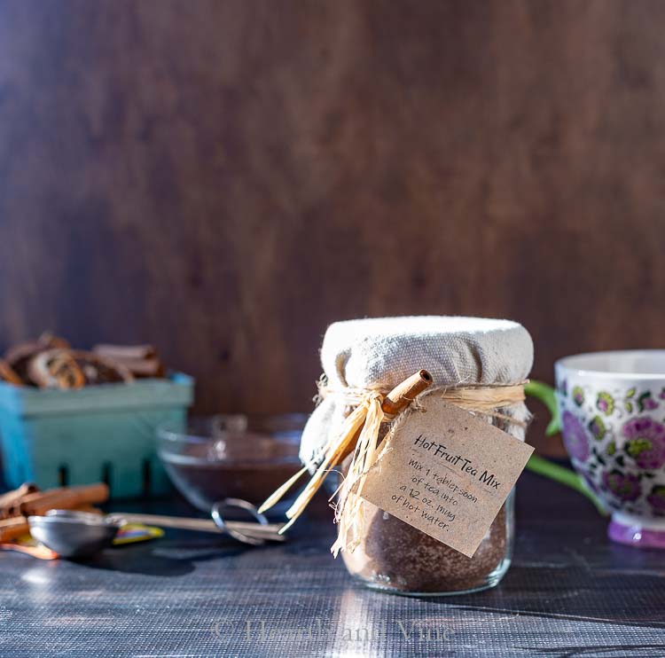 Fruit tea mix in jar with tag and cinnamon sticks